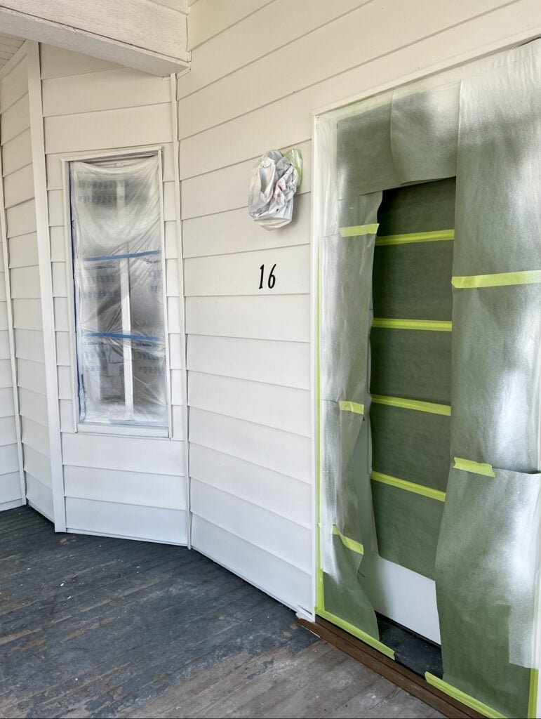 a white house with green door and plastic tape