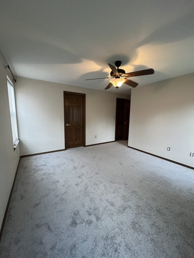 a room with a ceiling fan and a window