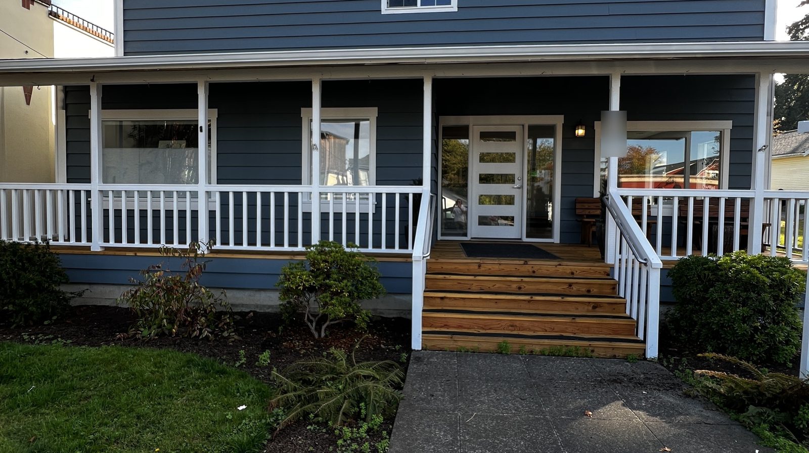 Building with blue siding, white porch rails and trim