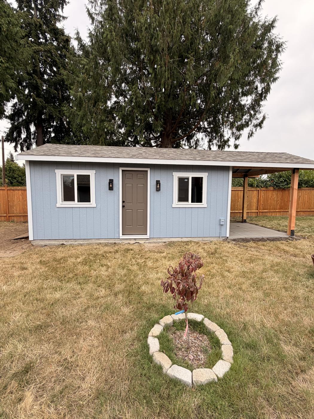 Backyard ADU in Bothell freshly painted blue-gray with white trim and a covered patio