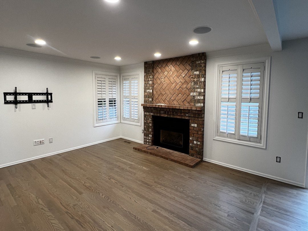 Family room in Mill Creek with fresh white walls and a brick fireplace