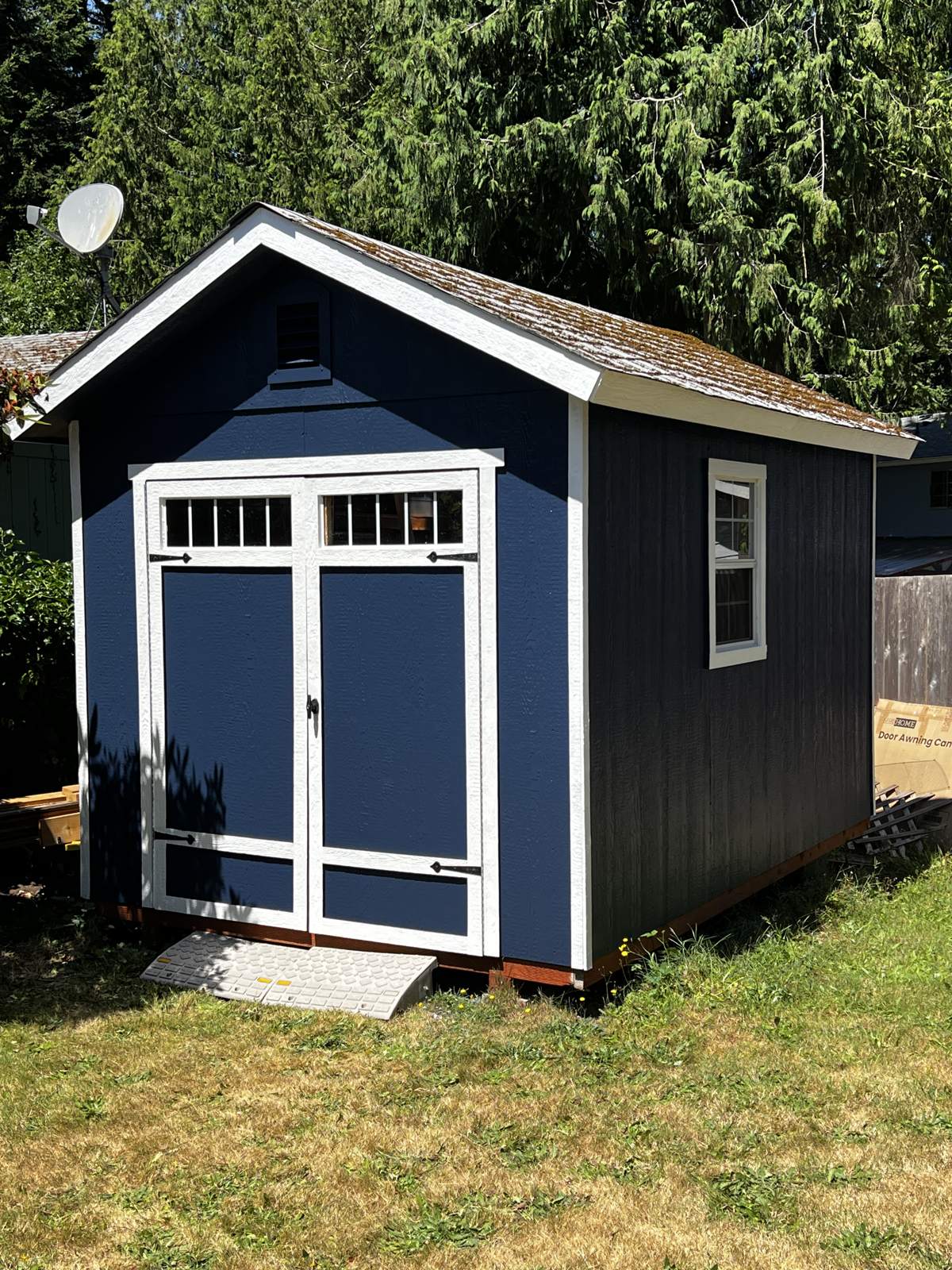 The same shed finished in navy with white trim and doors