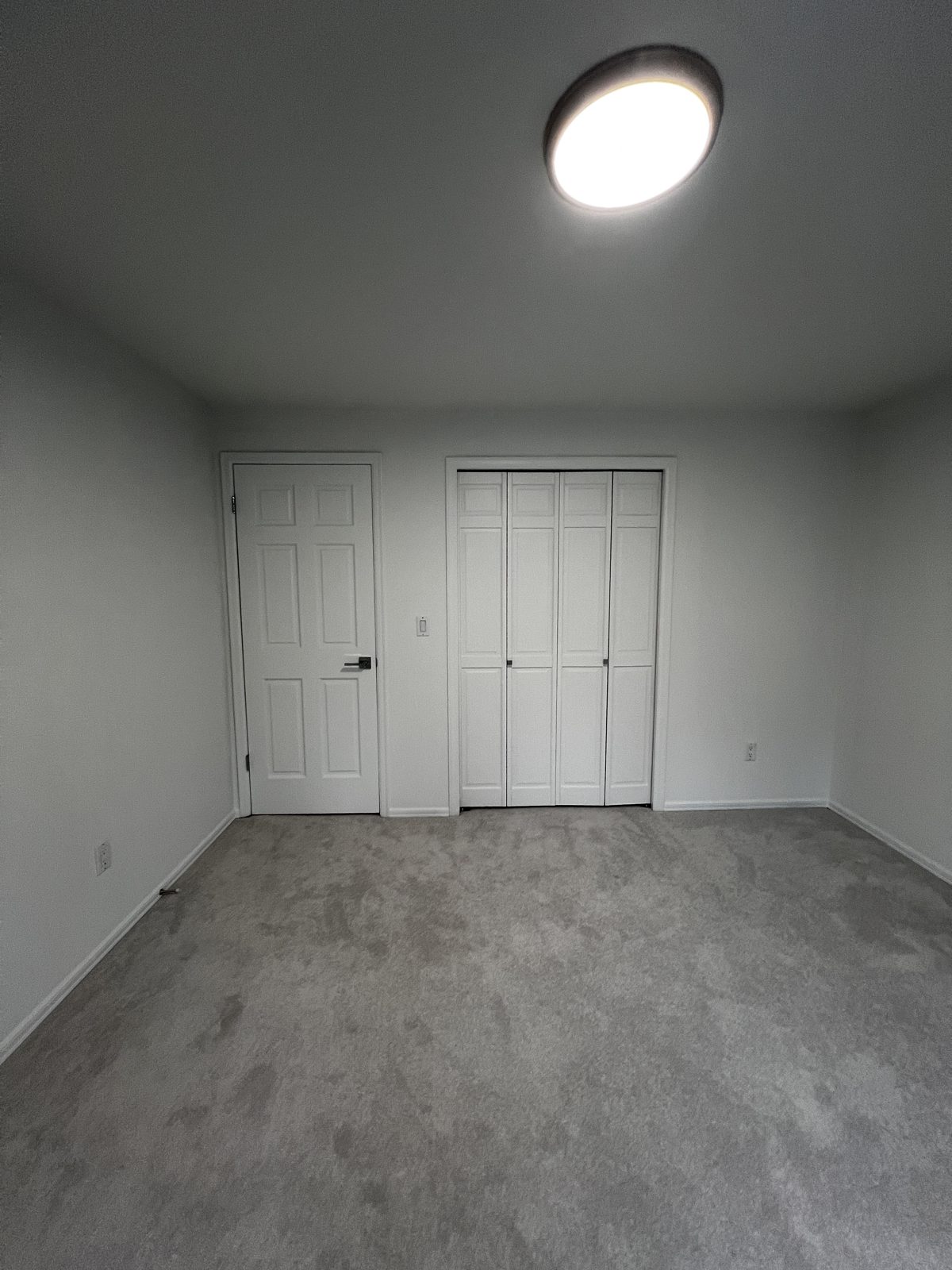 Rental turnover painting: empty bedroom freshly painted with white doors and closet
