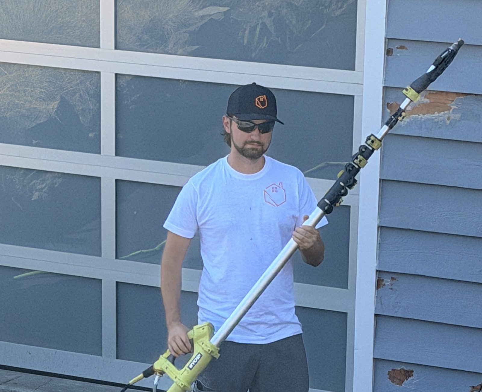 Miracle Painting crew member with a washing wand on an extension pole