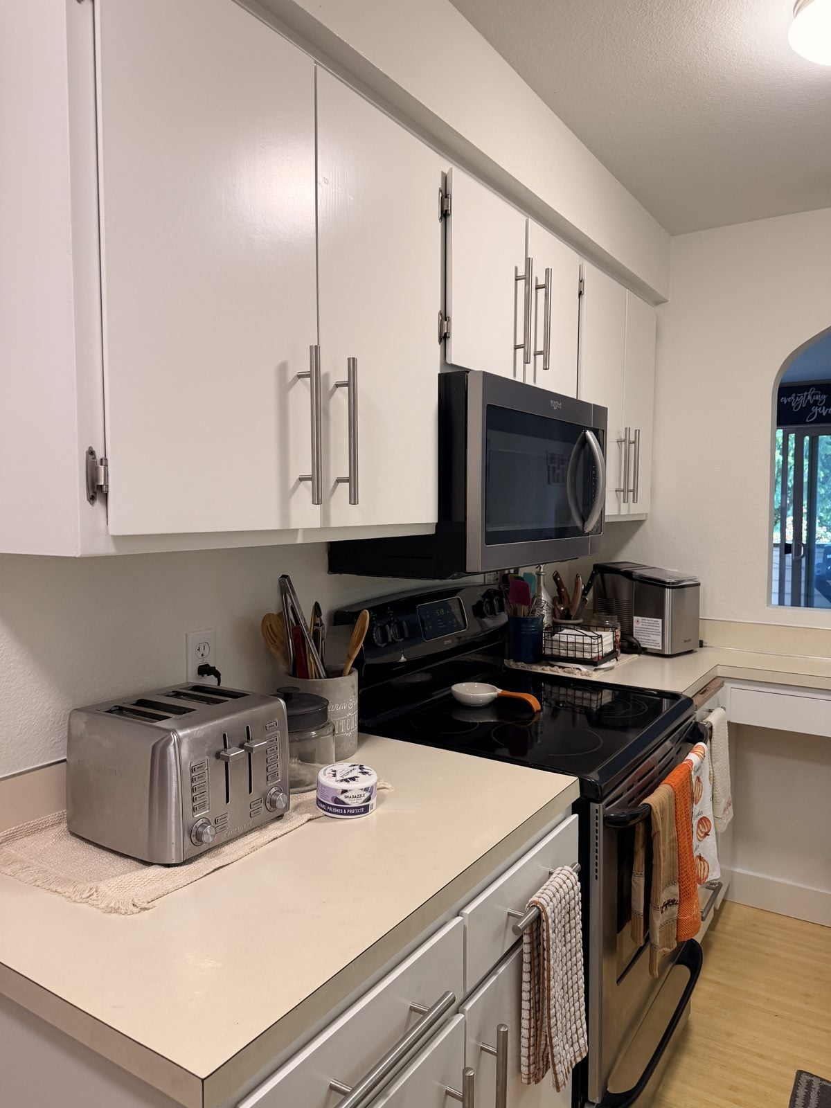 Upper and lower kitchen cabinets painted white around the range
