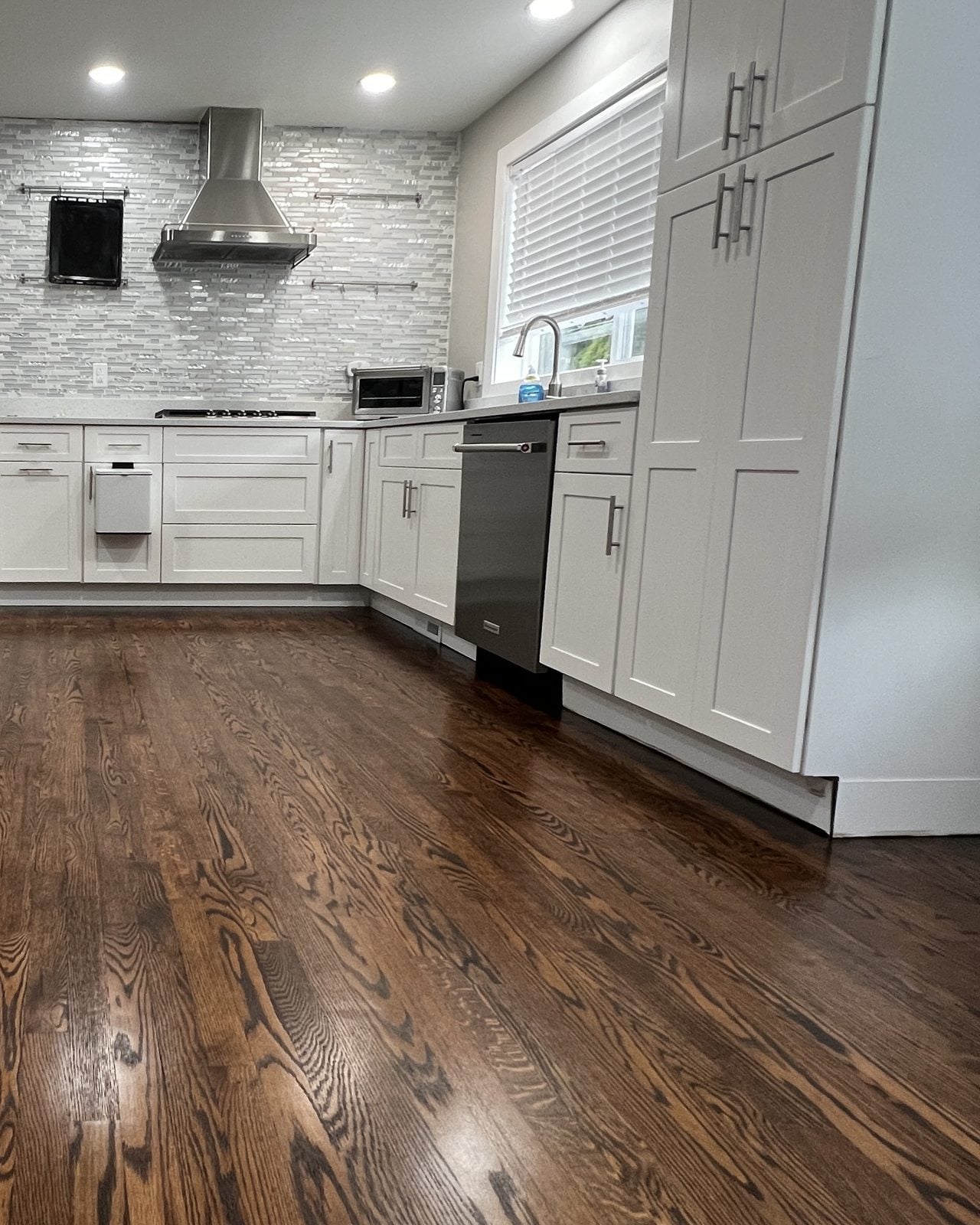 The same kitchen floor sanded and refinished in a rich dark stain