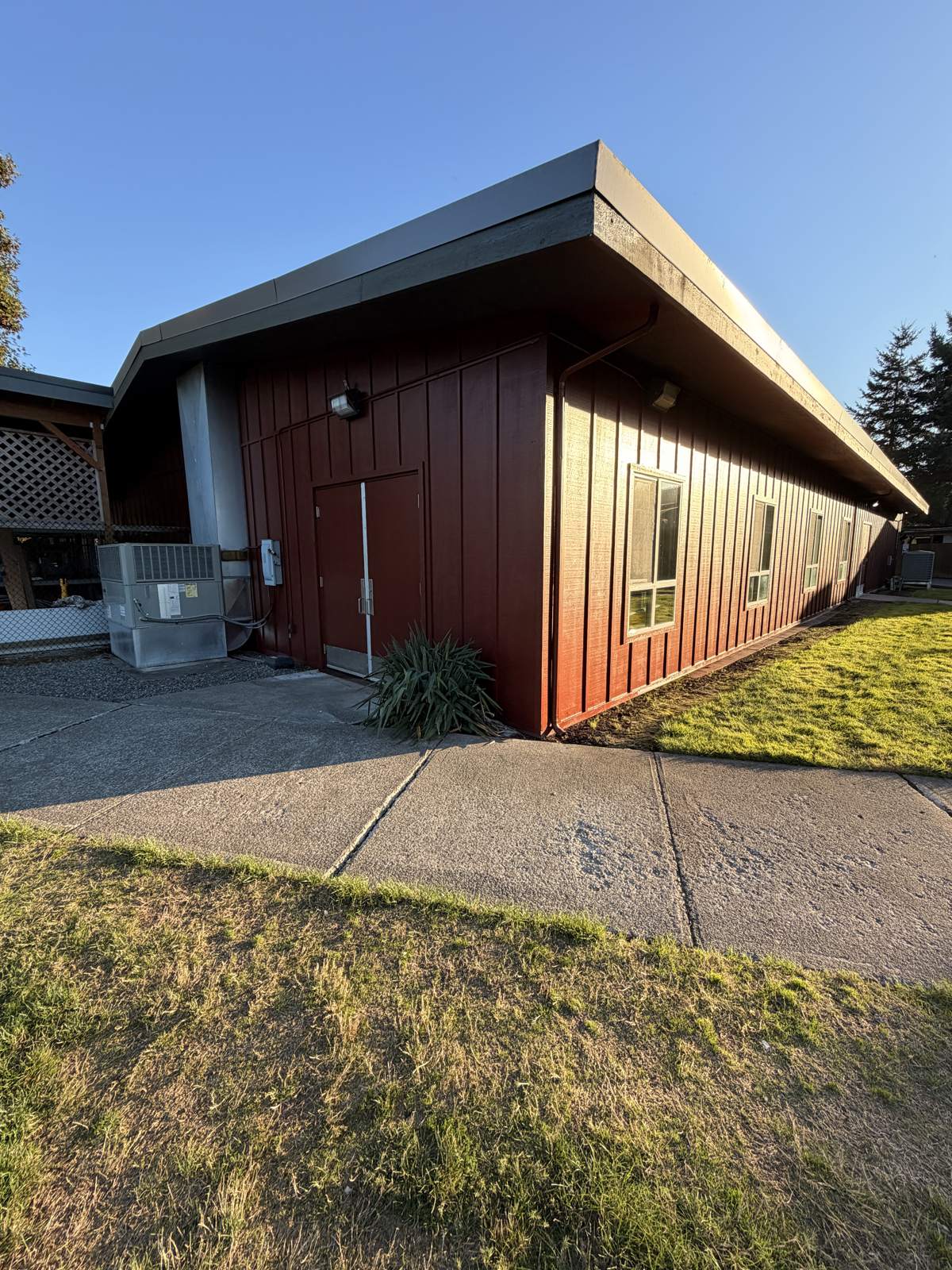 Commercial building with red board-and-batten siding and dark trim
