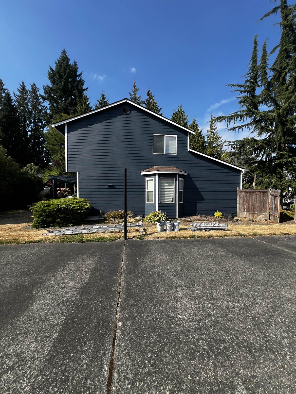 Same Everett home painted deep navy with white trim after siding repairs