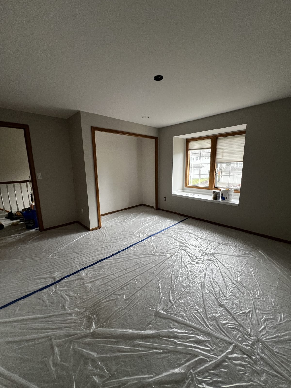 Room with floors fully covered in plastic and taped before painting