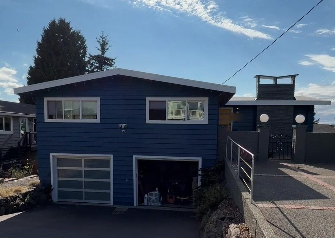 Front of the Edmonds house finished in deep navy with white trim and garage doors