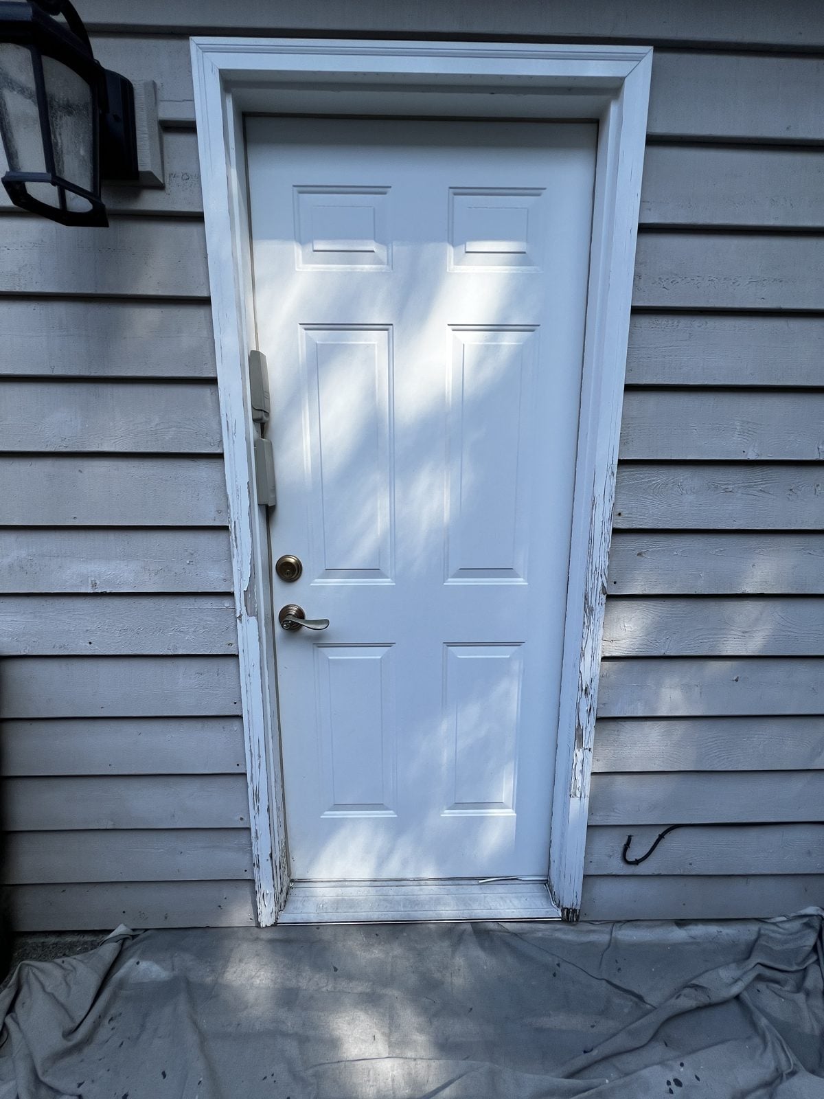 Worn exterior door with peeling paint on the frame