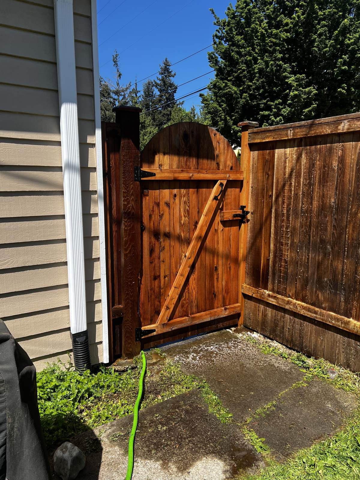 Arched wood gate in Brier stained a rich cedar tone