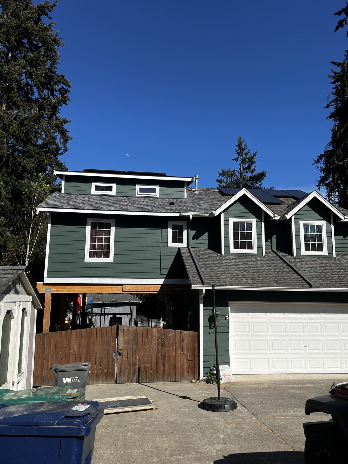 Lynnwood house with its new addition painted deep green with white trim to match the home