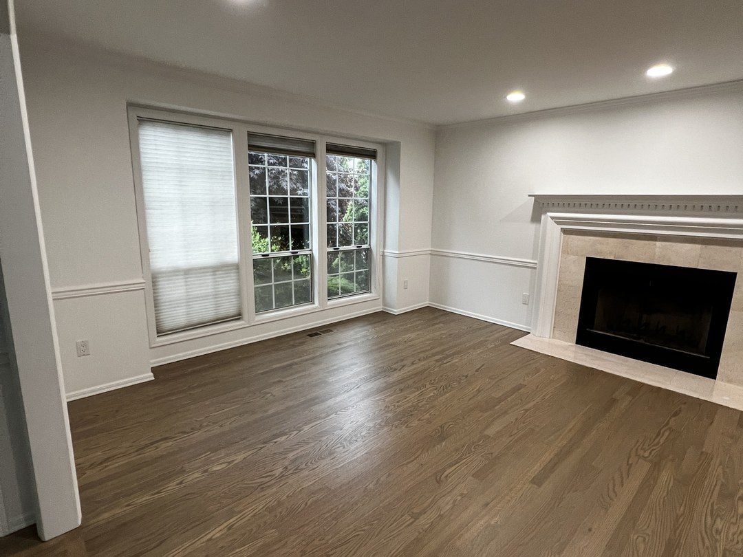 Living room in Mill Creek with white walls, wainscoting and a fireplace
