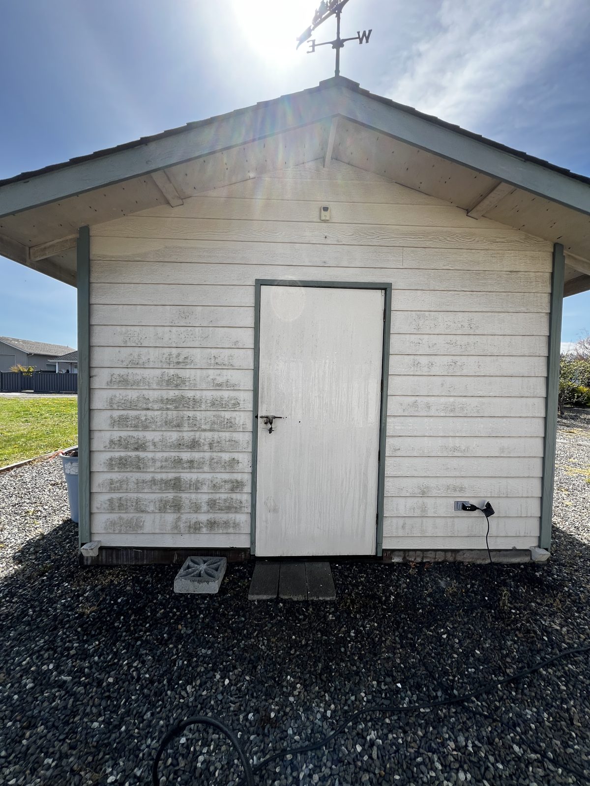 Shed siding with dark mildew streaks before washing