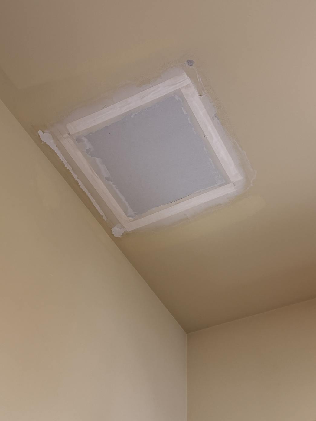 New drywall patch set into a vaulted ceiling and taped