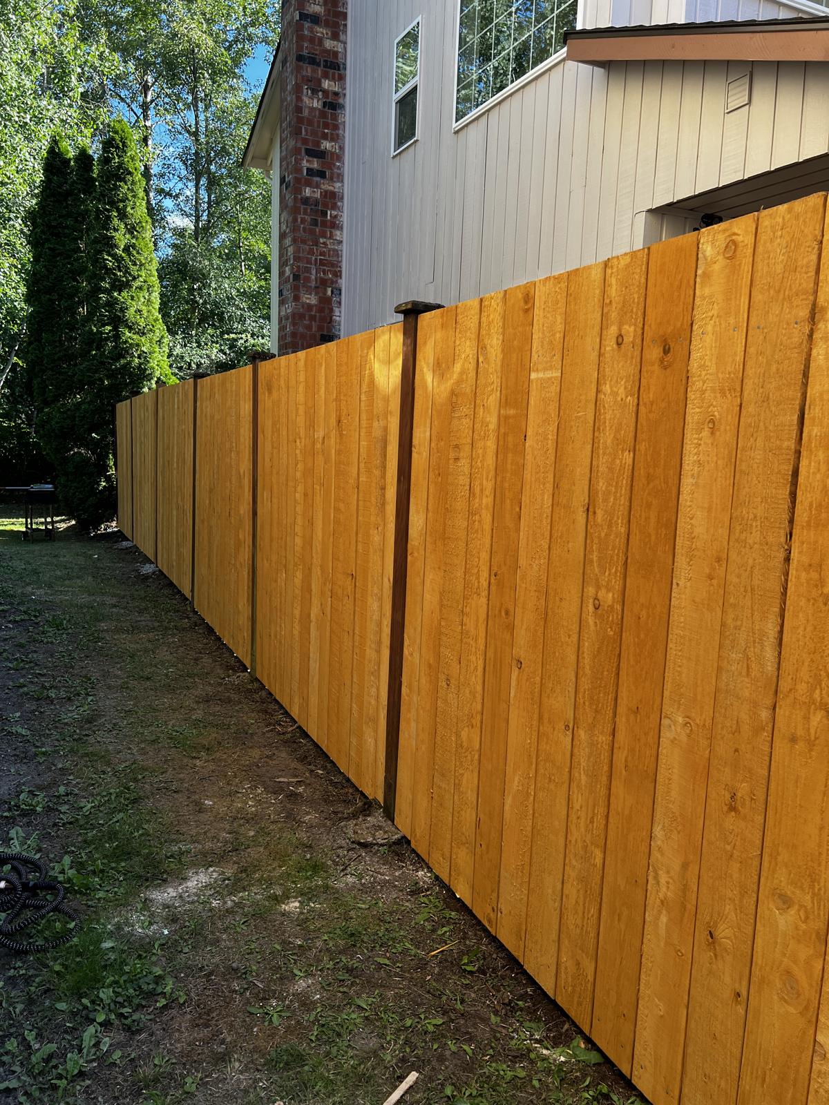 The same side-yard fence freshly stained