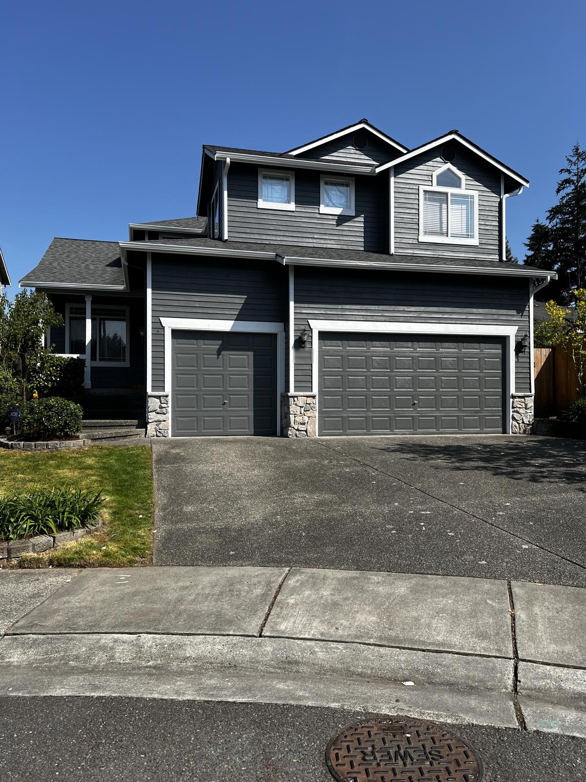 Two-story home repainted charcoal gray with crisp white trim