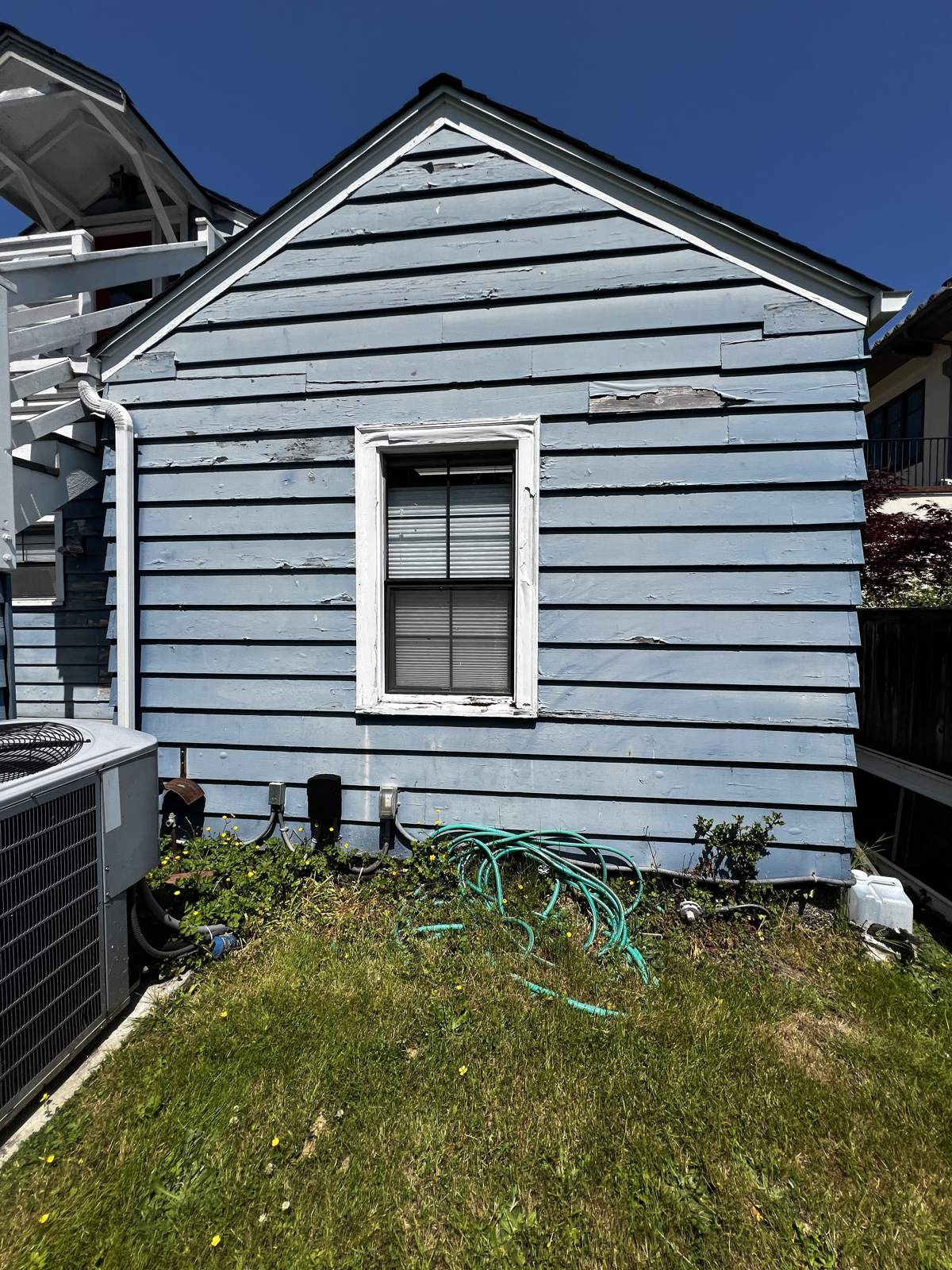 Commercial building with peeling light blue lap siding